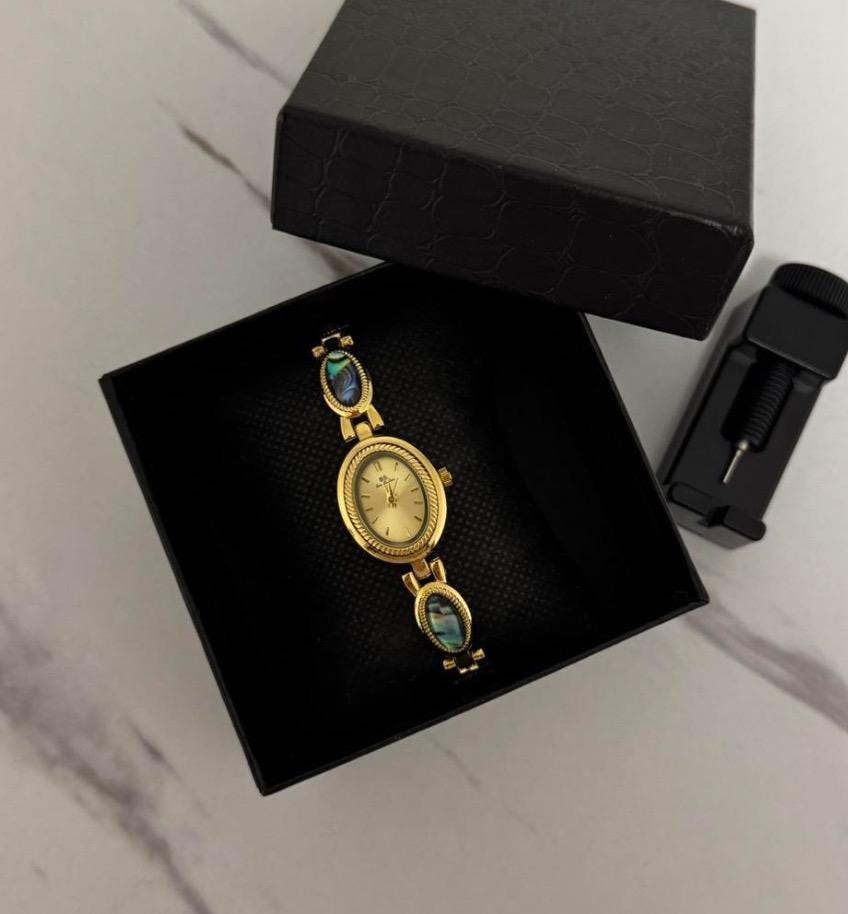 montre vintage en or et pierres bleues, montre délicate en ormeau à l'ancienne
